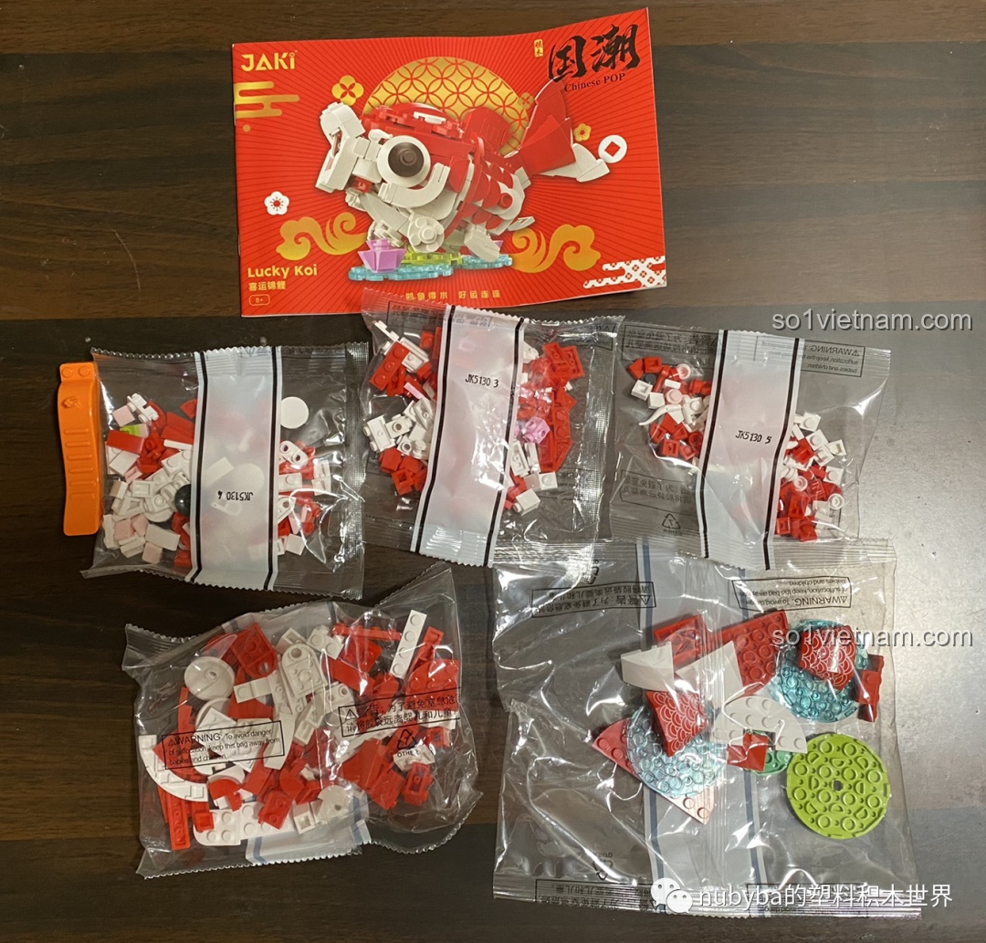 Các túi mảnh ghép đồ chơi lắp ráp Cá Chép May Mắn JAKI JK20236 được phân loại gọn gàng trên bàn.