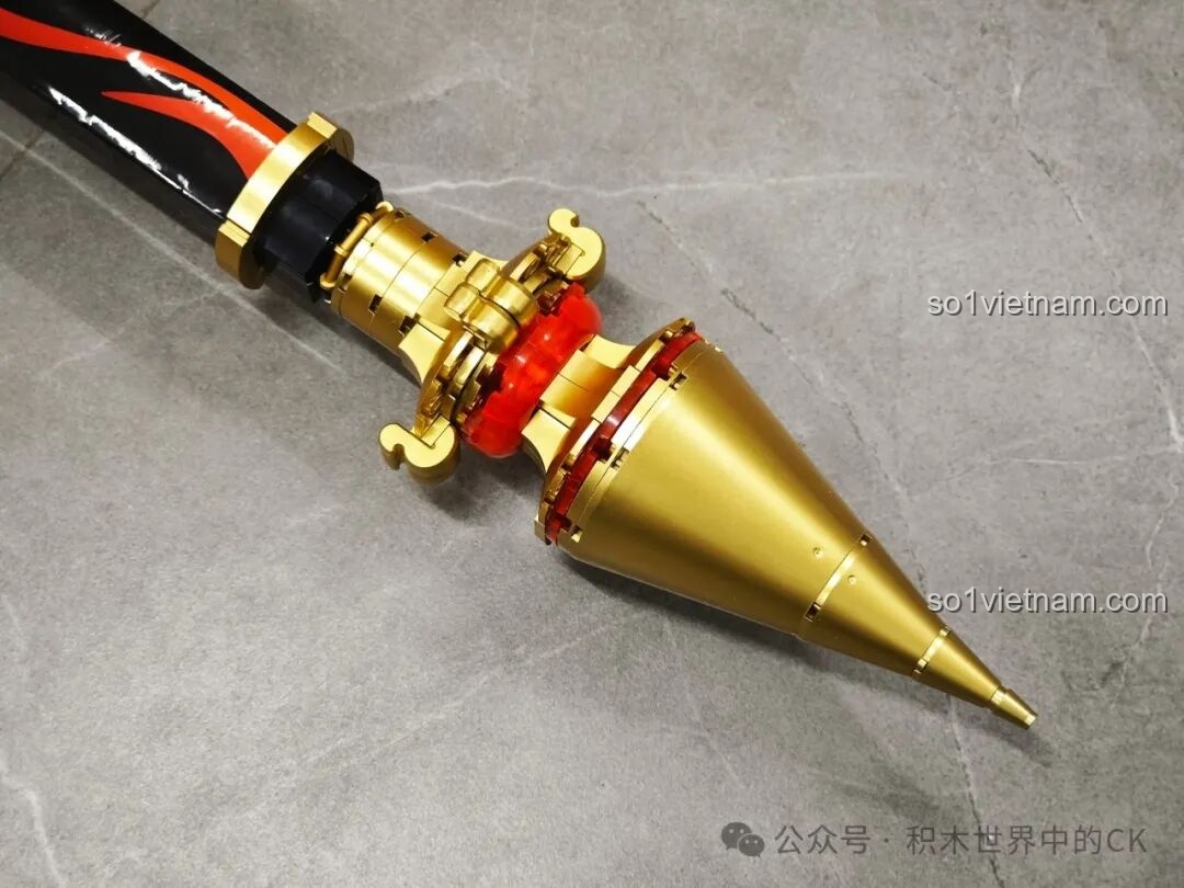 Cận cảnh chóp nhọn màu vàng đồng ở đuôi JIESTAR 58112 Trượng Hộ Ma Genshin Impact, chi tiết sắc sảo và tinh tế.