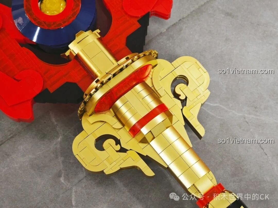 Chi tiết phần tay cầm màu vàng đồng của JIESTAR 58112 Trượng Hộ Ma Genshin Impact, với các họa tiết chạm khắc tinh tế.