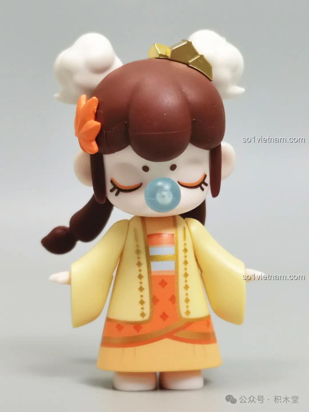 Cận cảnh minifigure Nanci mùa Thu với mái tóc búi củ tỏi, trang phục màu cam vàng và biểu cảm đáng yêu.