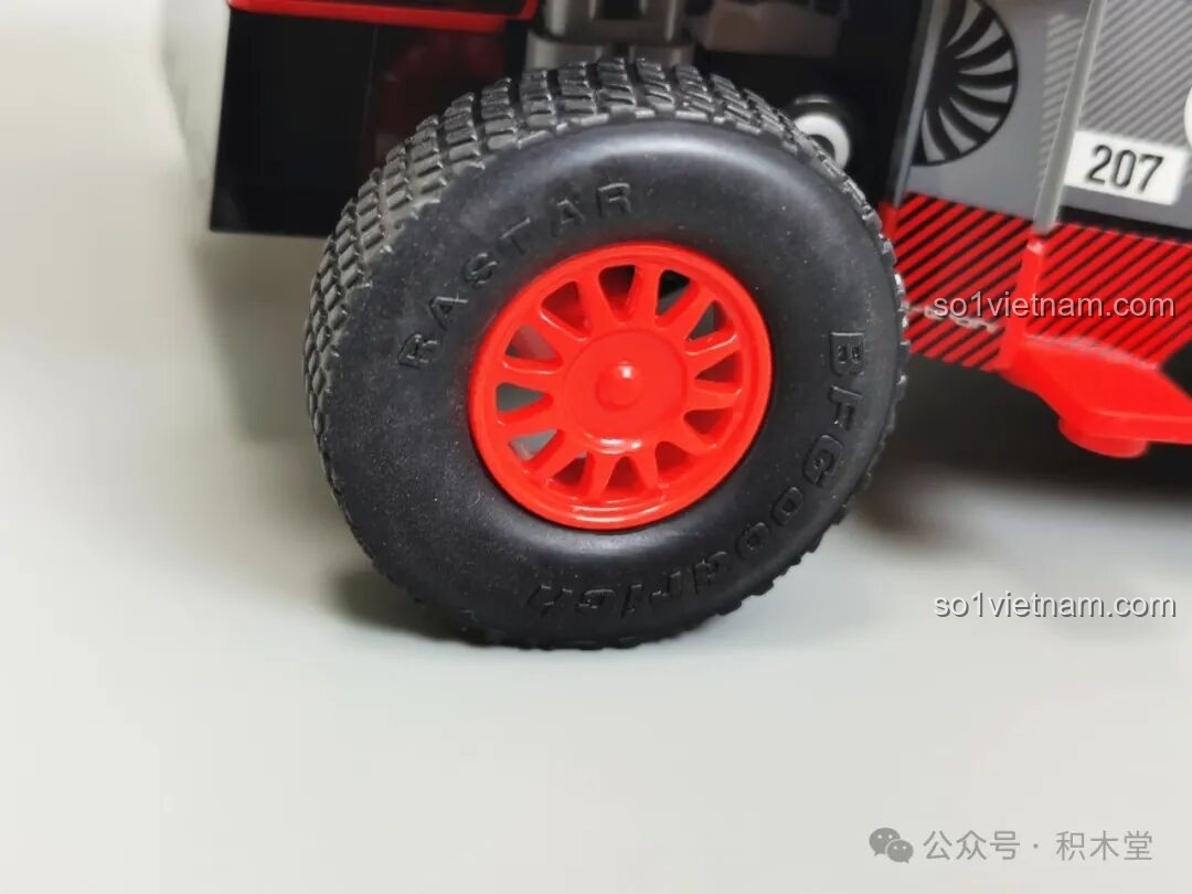 Cận cảnh bánh xe và lốp của mô hình RASTAR 10120 Audi RS Q e-tron E2, với vành đỏ và lốp gai hầm hố, có logo RASTAR.