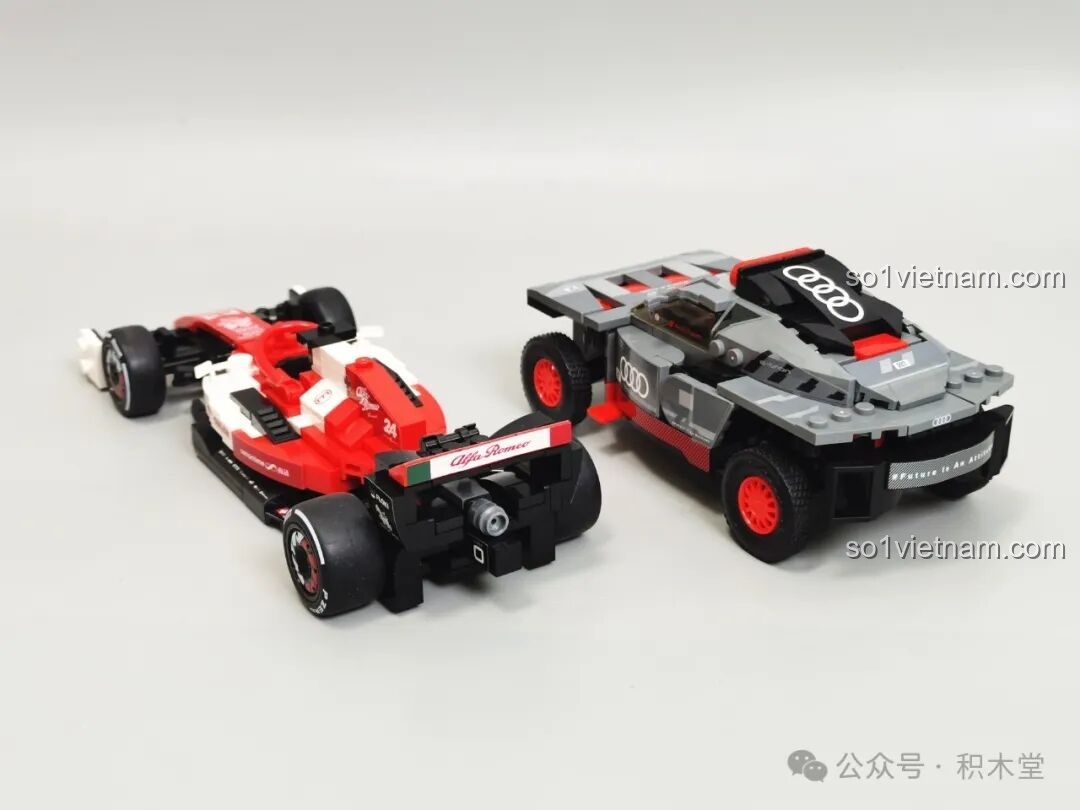 Mô hình RASTAR 10120 Audi RS Q e-tron E2 và xe F1 chụp từ phía sau, cho thấy chi tiết đuôi xe của cả hai.