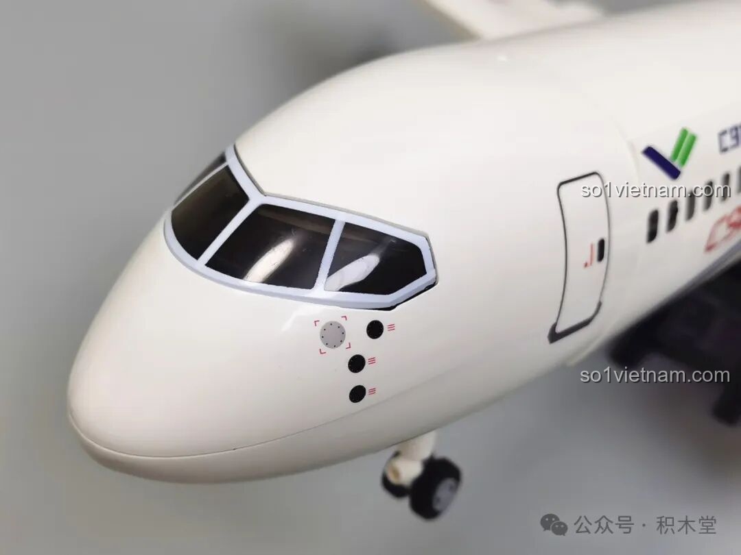 Phần cánh máy bay với các chi tiết cửa thoát hiểm và logo, thể hiện sự tỉ mỉ trong thiết kế của đồ chơi mô hình Máy bay chở khách C919 TOP TOY TC1210.