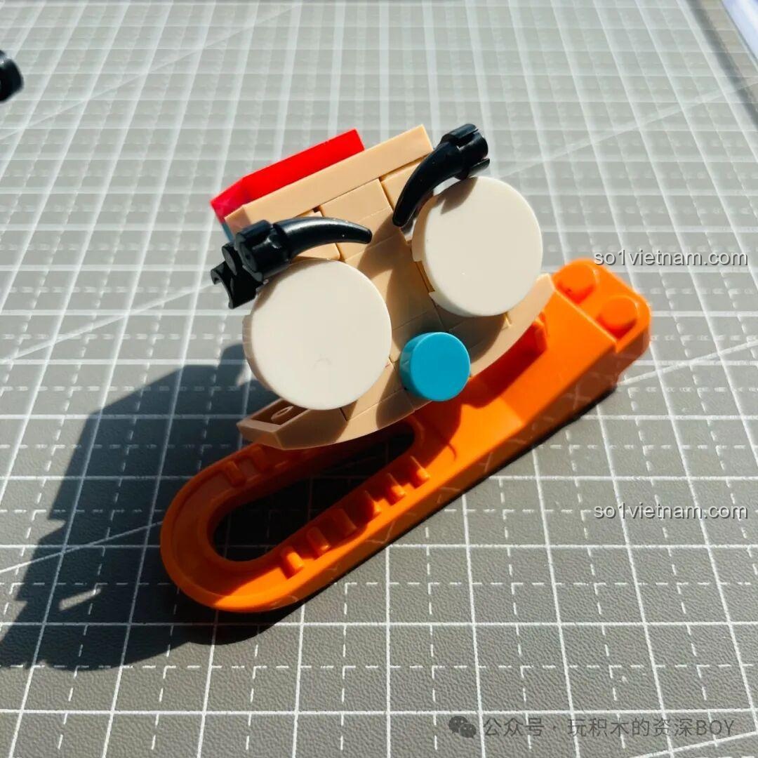 Review quá trình lắp ráp khuôn mặt của mô hình Tuole L8004 Kabutack, với đôi mắt to tròn và chiếc mũi xanh đặc trưng.