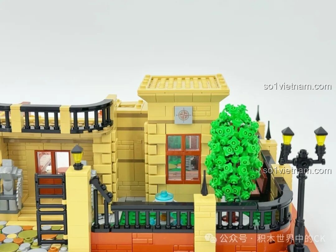 Chi tiết bên ngoài lâu đài Học viện Pháp thuật ZHEGAO 613004 với cây xanh, cửa sổ và một la bàn nhỏ trên tường, thể hiện sự chú ý đến từng chi tiết.