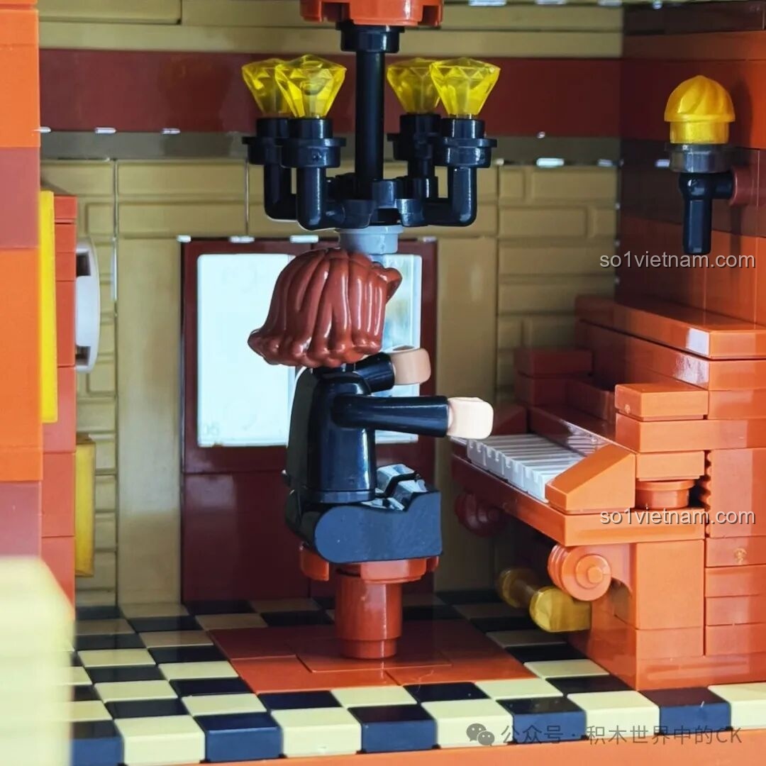 Minifigure đang ngồi đọc sách trong vườn của Học viện Pháp thuật ZHEGAO 613004 dưới ánh đèn LED, tạo không gian yên bình.