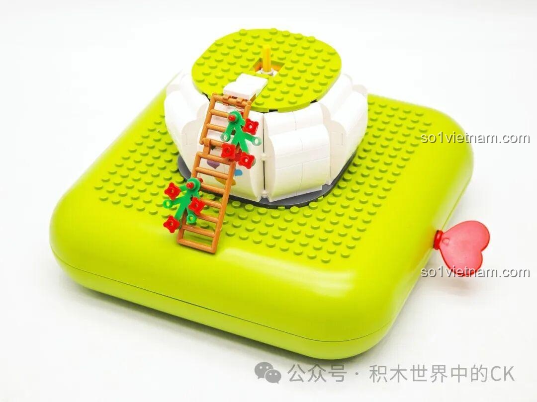 Giai đoạn đầu lắp ráp bộ ZHEGAO 663014 Ngôi Nhà Chim Hoa Gấu Mầm, với phần đế và chiếc thang gỗ nhỏ đang được hoàn thiện.