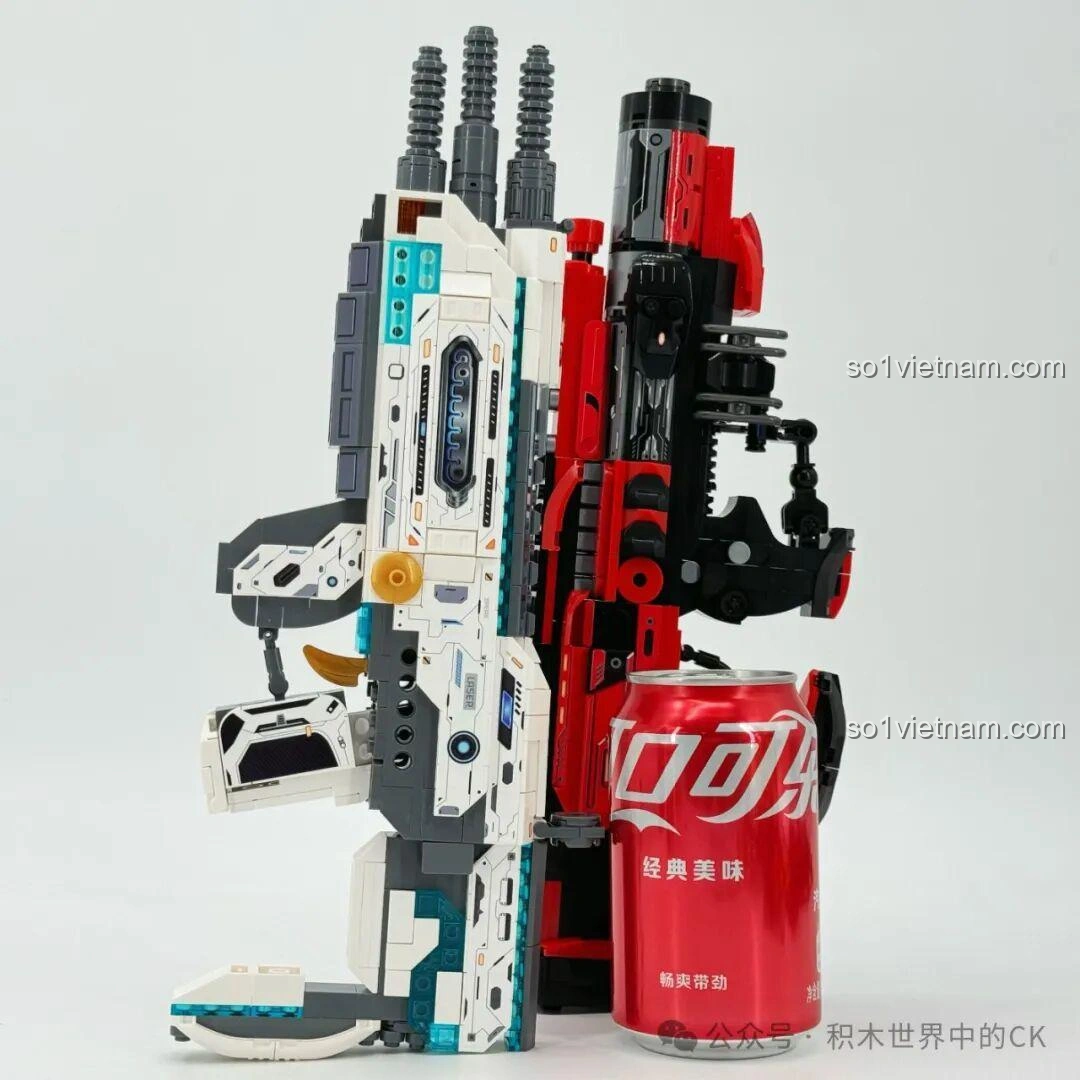 ZHEGAO 918019 Súng trường điện từ Bạch Dương và 918022 Súng phun lửa Sư Tử đặt cạnh lon nước để so sánh kích thước.