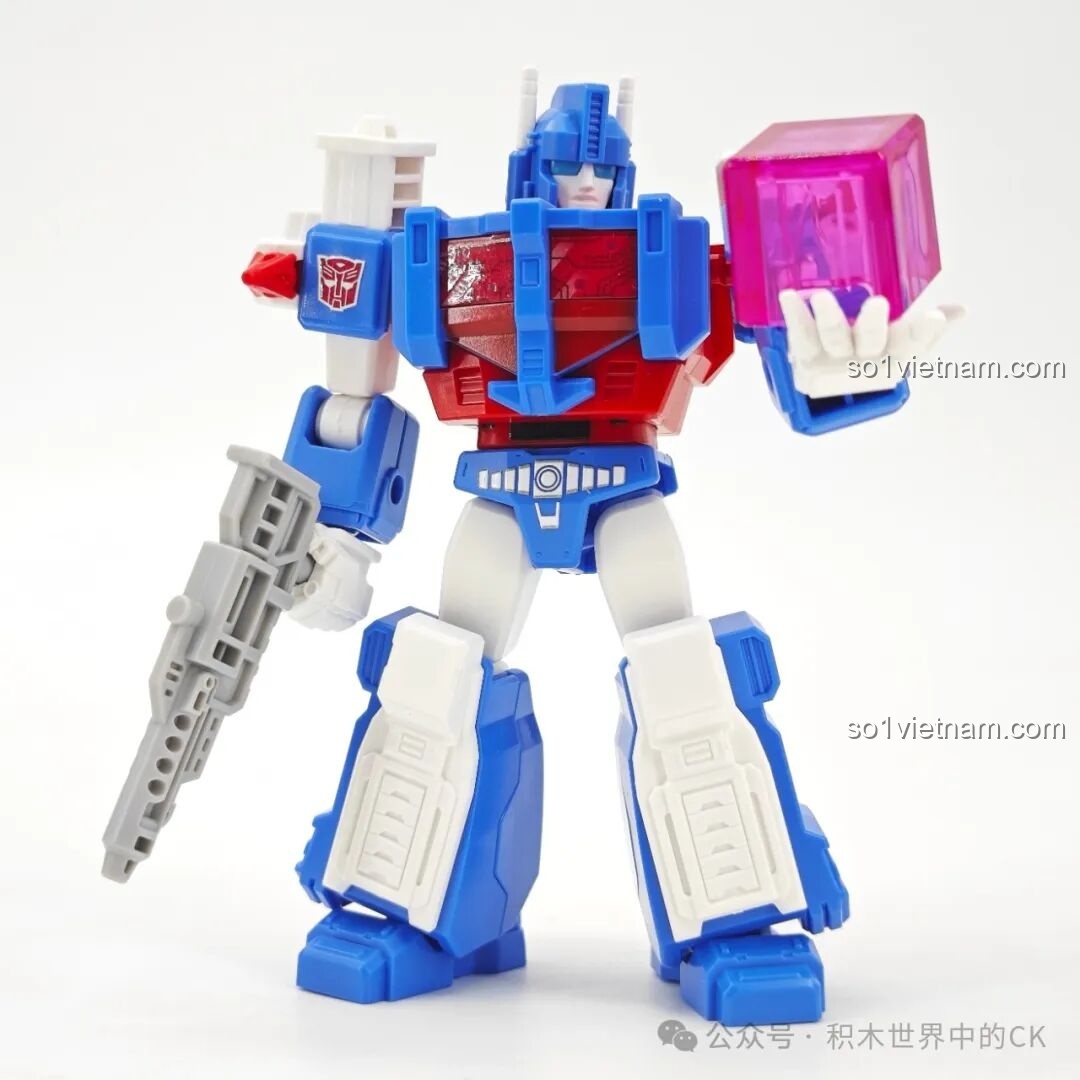 Mô hình robot Ultra Magnus BLOKEES 71104 Transformers đang nâng một khối năng lượng màu hồng, thể hiện phụ kiện đi kèm.
