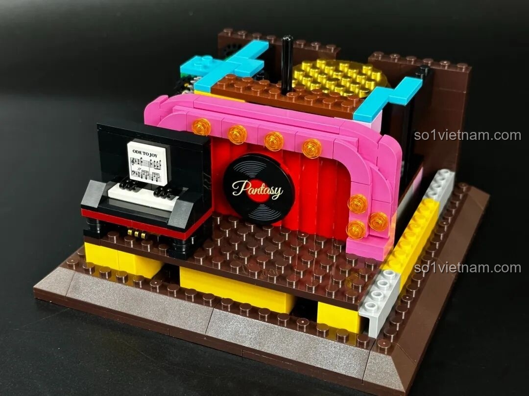 Sân khấu mini với đàn piano và micro bên trong bộ Pantasy Gramophone 85009, thể hiện sự sáng tạo trong thiết kế mô hình.