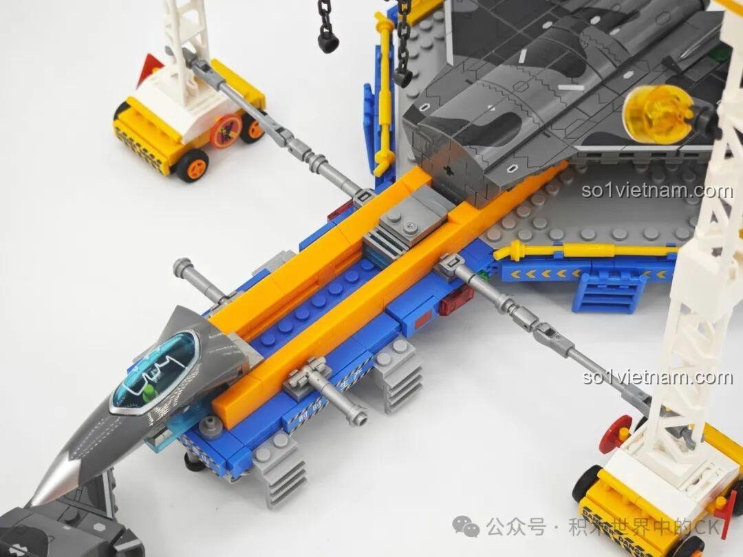 Mô hình J-20 và các minifigures trên dây chuyền sản xuất Sembo 202256, được chiếu sáng bởi đèn LED, tạo không khí làm việc.