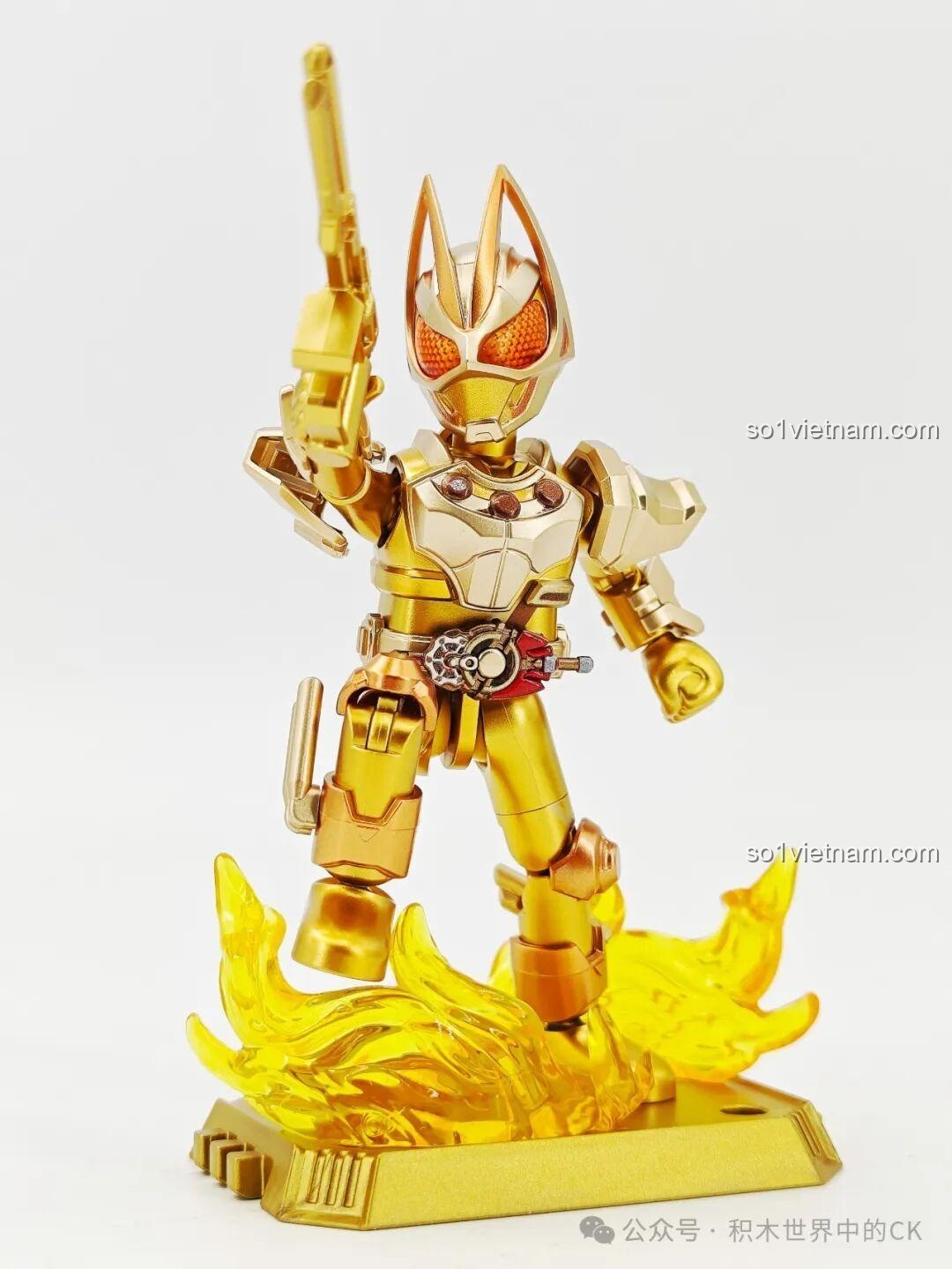 Kamen Rider Geats phiên bản vàng tạo dáng hành động với khẩu súng trên đế trưng bày, sẵn sàng cho mọi trận chiến.
