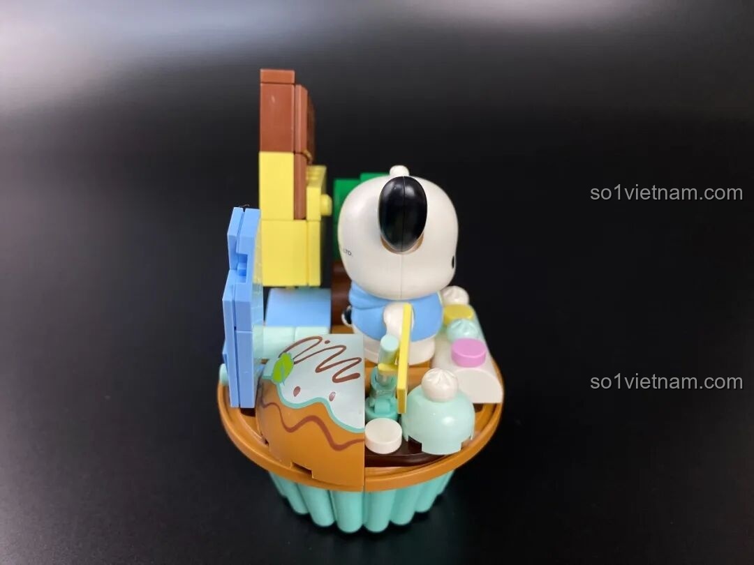 Mô hình Keeppley Pochacco cupcake nhìn từ bên hông trái, với chi tiết bánh quy trang trí.