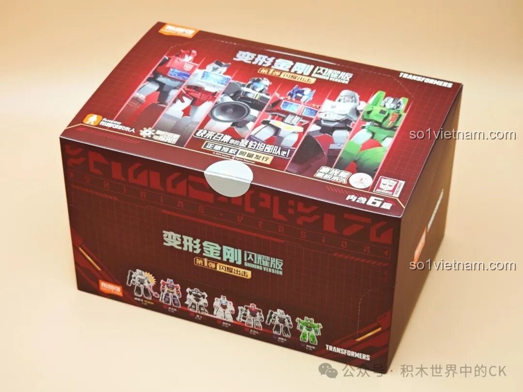 Hộp sản phẩm Transformers Shining Version - Tập 1 với thiết kế màu đỏ đô và hình ảnh các robot Transformer nổi bật