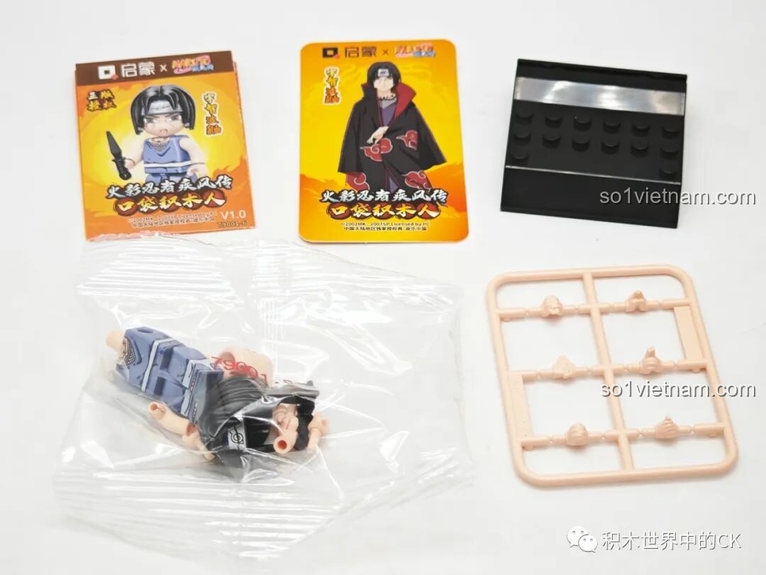 Mở hộp minifigure Uchiha Itachi, bộ Qman 79001, gồm các chi tiết nhân vật, kunai, thẻ bài và đế trưng bày.