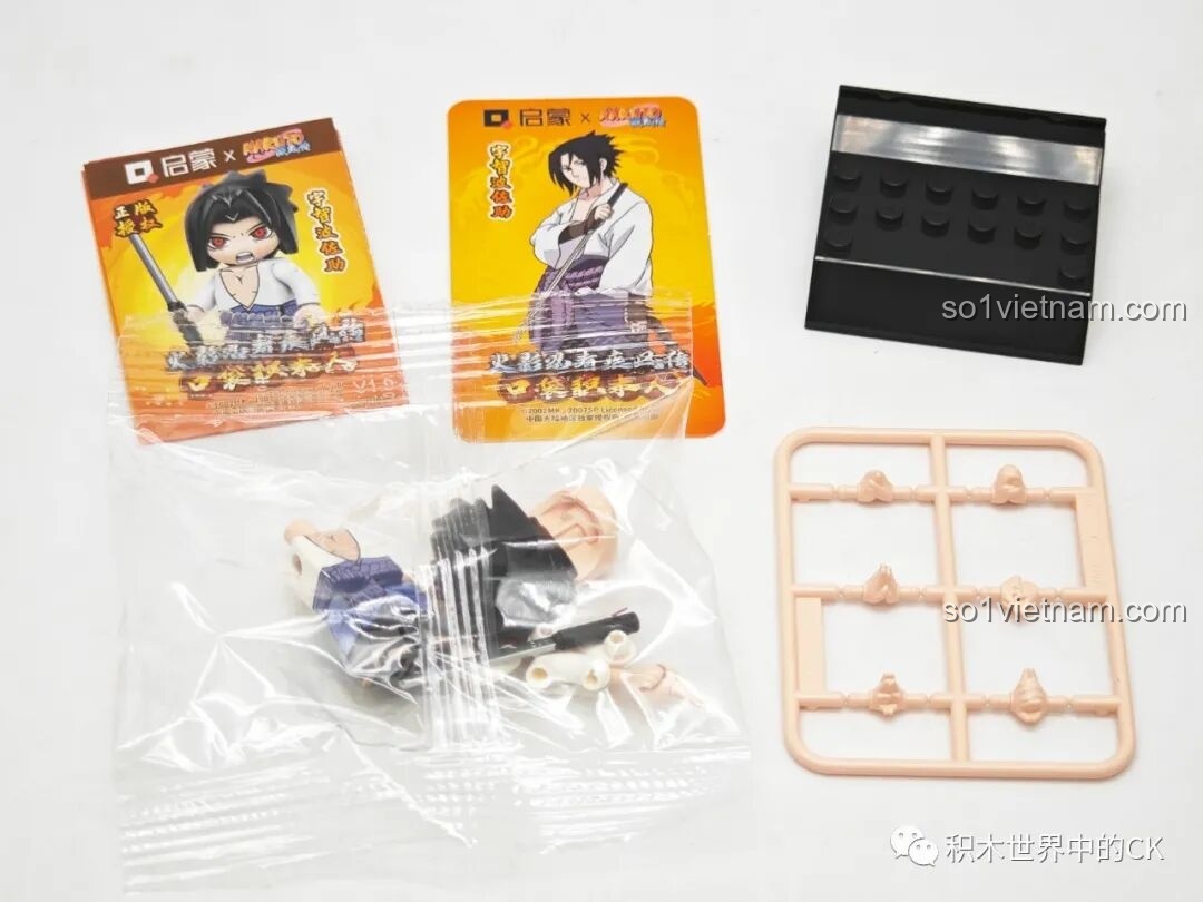 Mở hộp minifigure Uchiha Sasuke, bộ Qman 79001, gồm các chi tiết nhân vật, kiếm, thẻ bài và đế trưng bày.