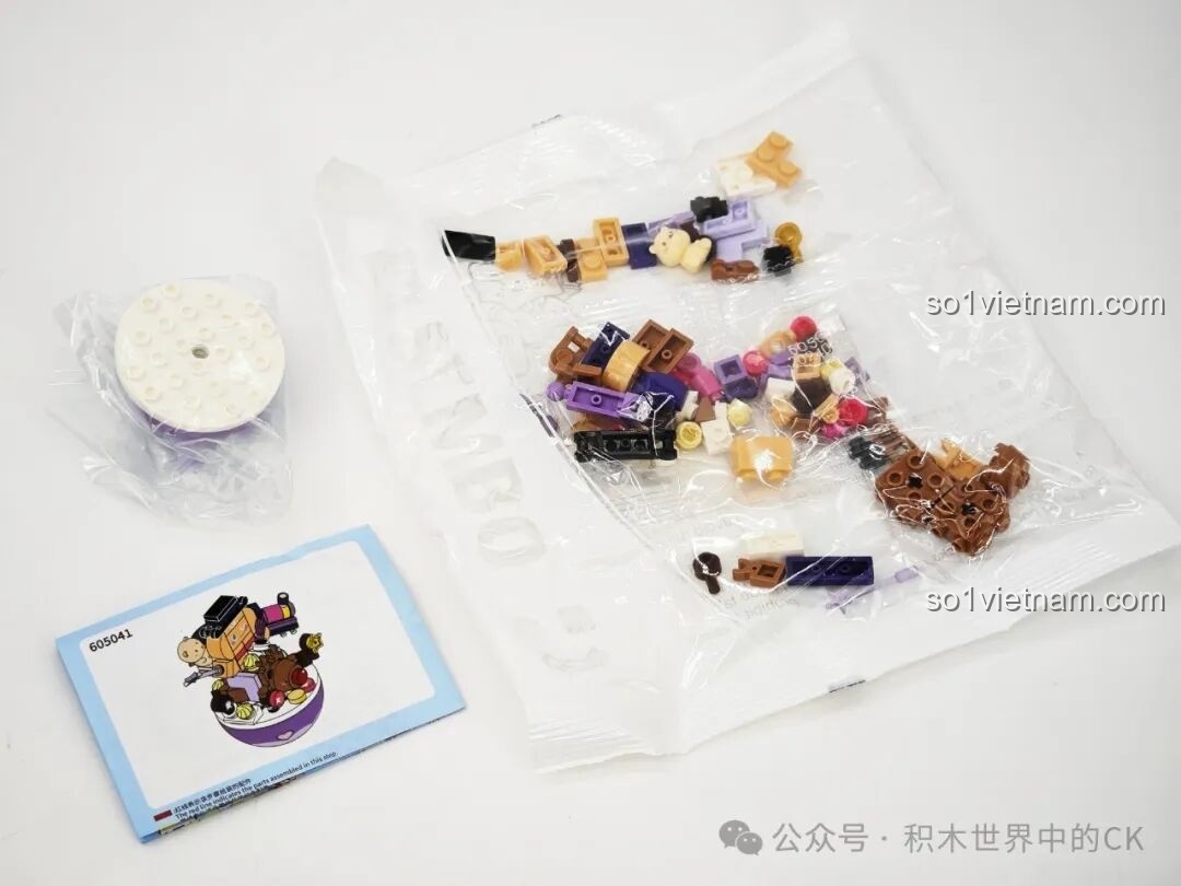 Bên trong hộp 605041: các mảnh ghép màu nâu, tím, hồng và sách hướng dẫn, chuẩn bị lắp ráp Bánh Gừng Phép Thuật.