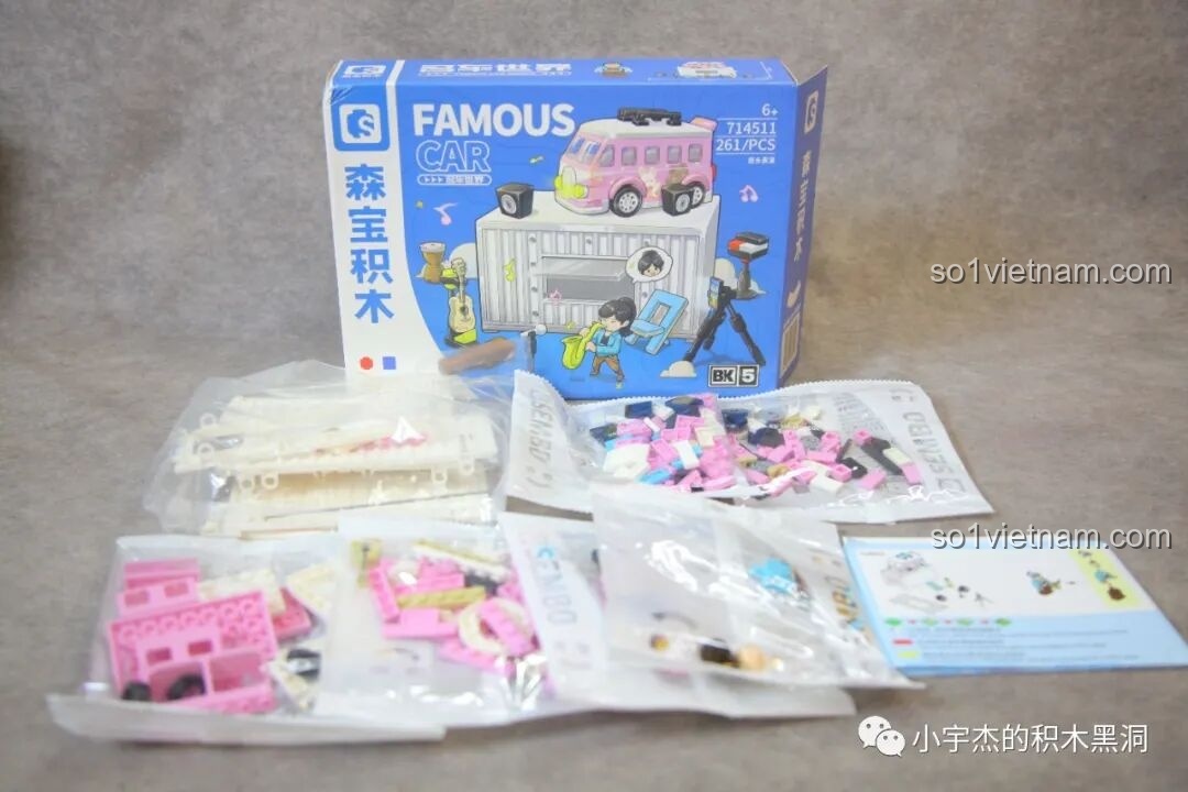 Mở hộp bộ đồ chơi lắp ráp Sembo 714511 Biểu Diễn Đường Phố, bên trong có các túi chi tiết màu trắng và hồng.