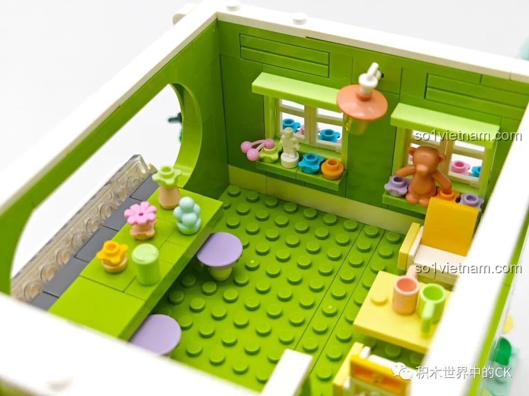 Chi tiết nội thất tầng trên của bộ xếp hình ZHEGAO 612003 Cửa hàng trà chanh, với ghế và bàn.